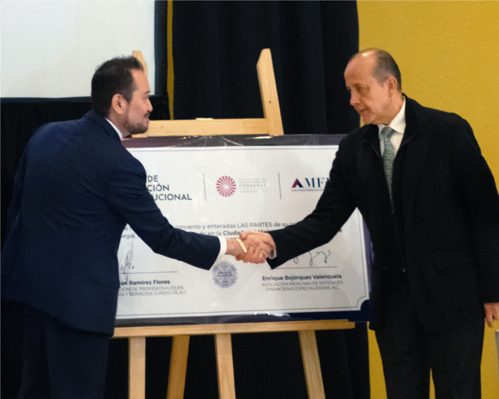 Presidente de la APCOB y Presidente de la AMFE dandose un apretón de manos después de firmar.